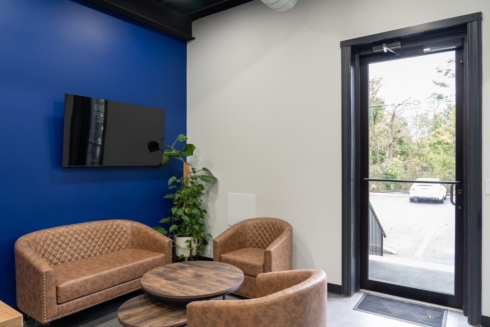 Lobby seating area at Cohen Mortgage in Cincinnati, with brown leather chairs and a Cohen Blue accent wall.